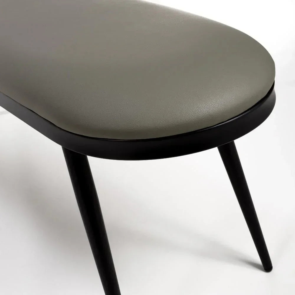 Grey upholstered dining bench with black metal legs, close-up on seat and legs