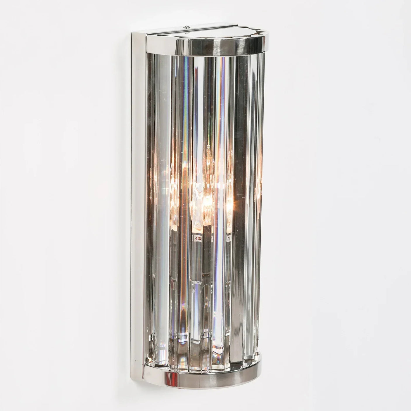Chrome and glass wall light with vertical panels mounted on white wall