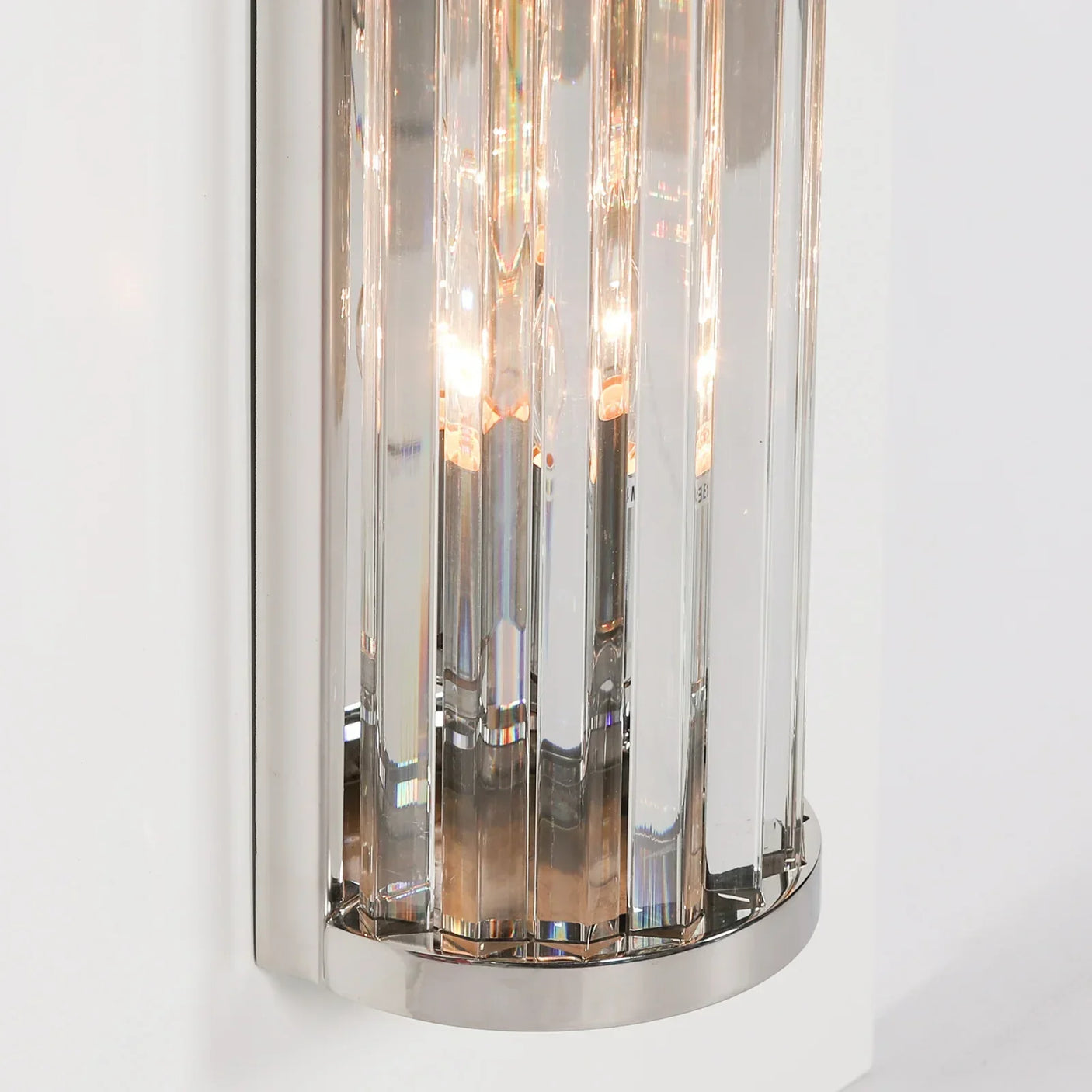 Modern wall light with clear glass panels and chrome frame mounted on white wall