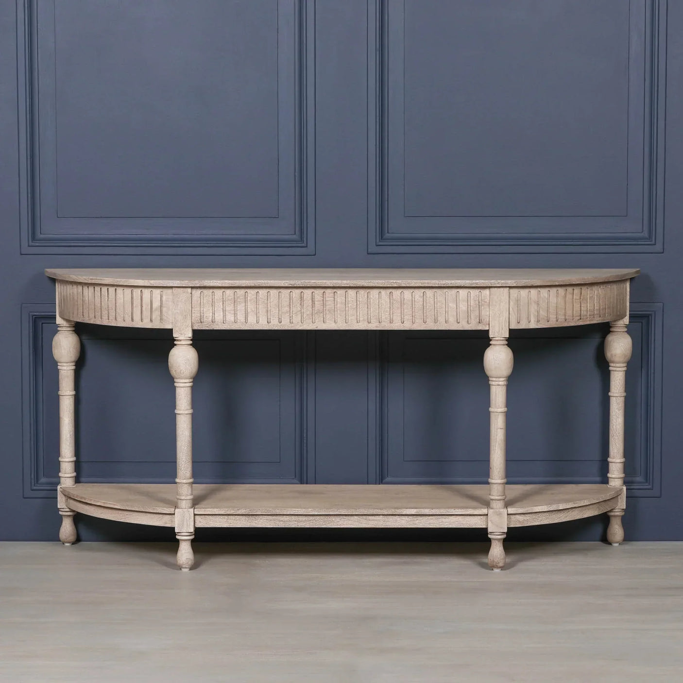 Beige wooden console table with fluted apron and turned legs against blue panel wall