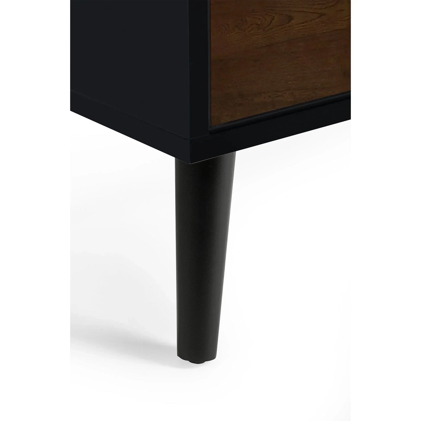 Close-up of black tapered leg and walnut side panel on drawer chest