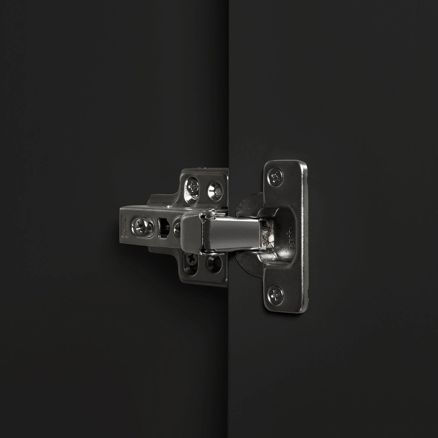 Closeup of metal hinge on black wardrobe door with matte finish