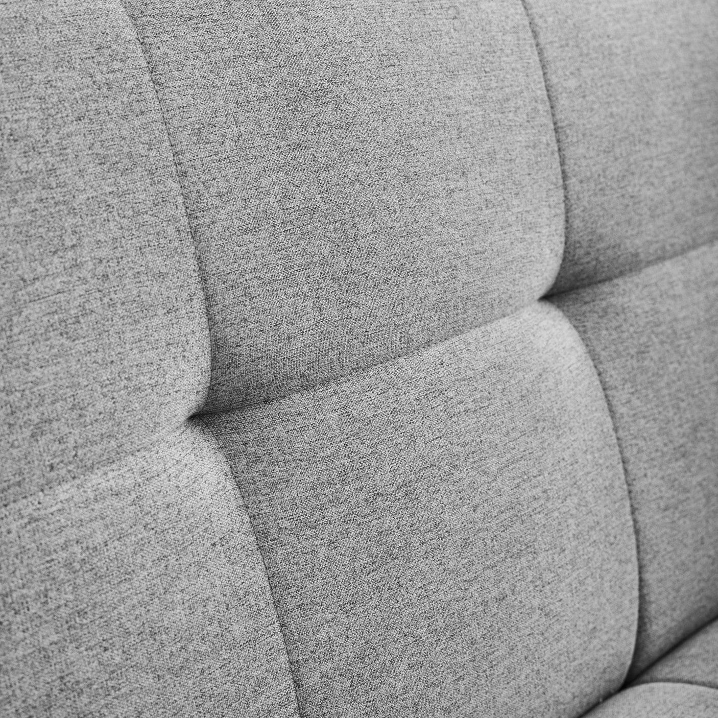 Closeup of grey fabric sofa backrest with square stitched upholstery