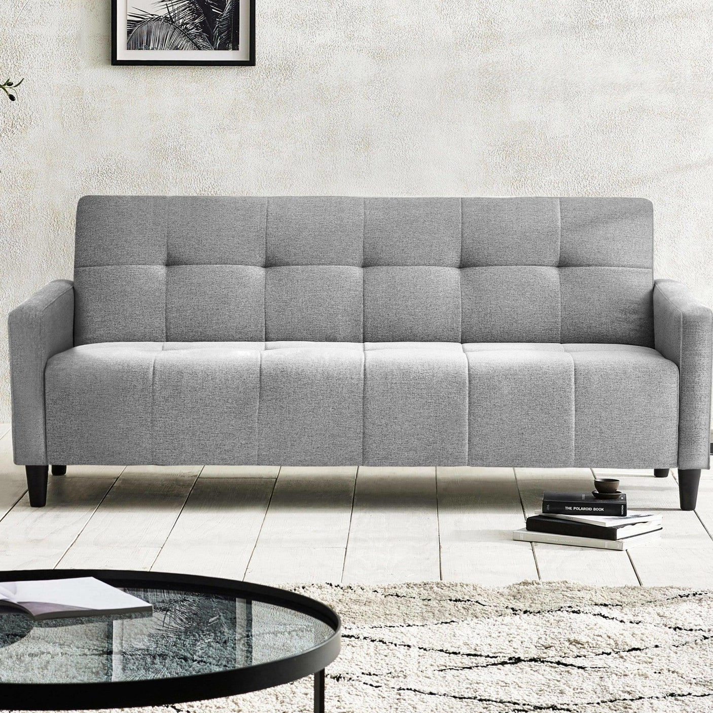 Light grey fabric sofa with square tufted upholstery in modern living room setting