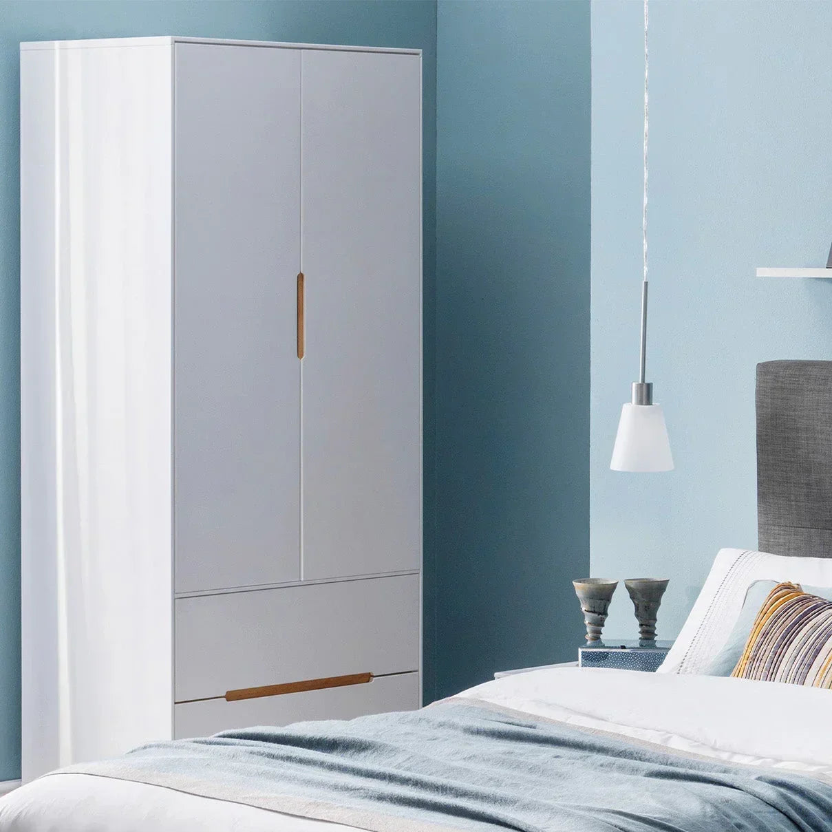 White combination wardrobe with wooden handles in modern bedroom setting