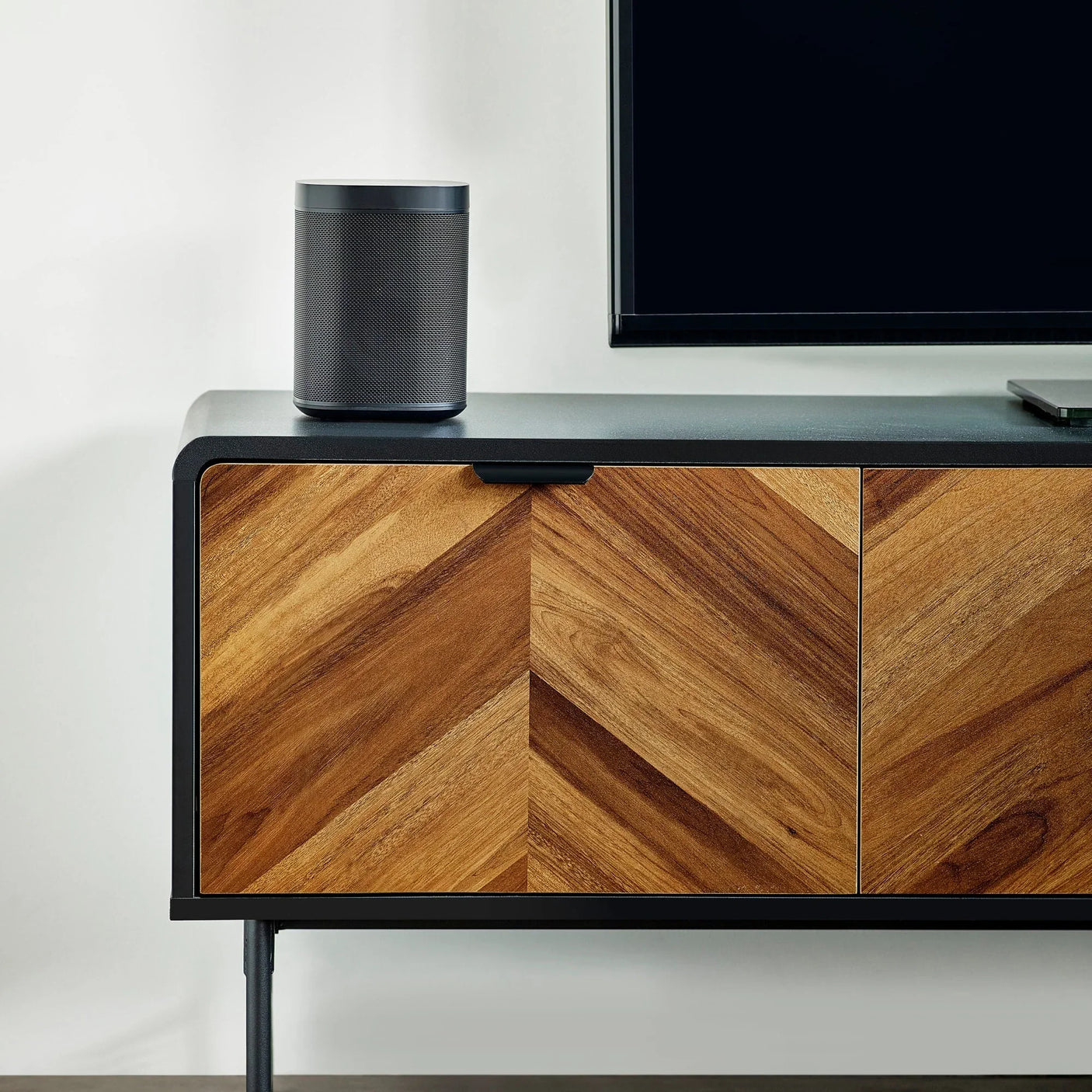 Chevron wood sideboard with black metal frame and speaker on top, modern living room furniture