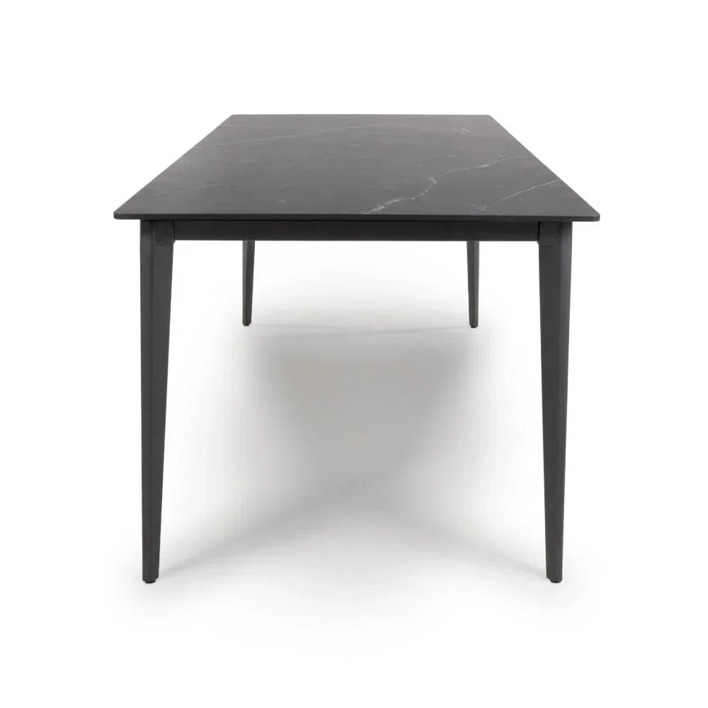 Rectangular black dining table with slim legs and smooth surface, front angle view
