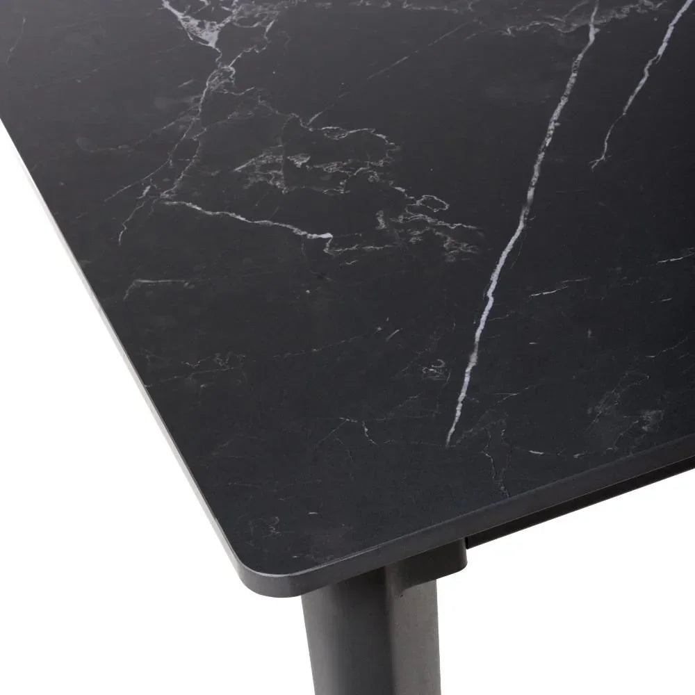 Black marble dining table corner with slim legs and white veining detail