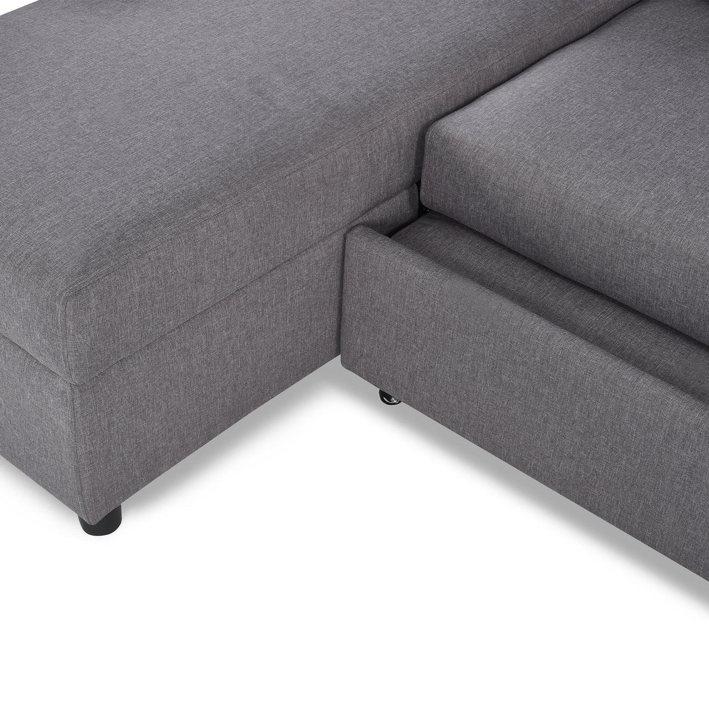 Grey sofabed with visible storage drawer and fabric upholstery, close-up corner view
