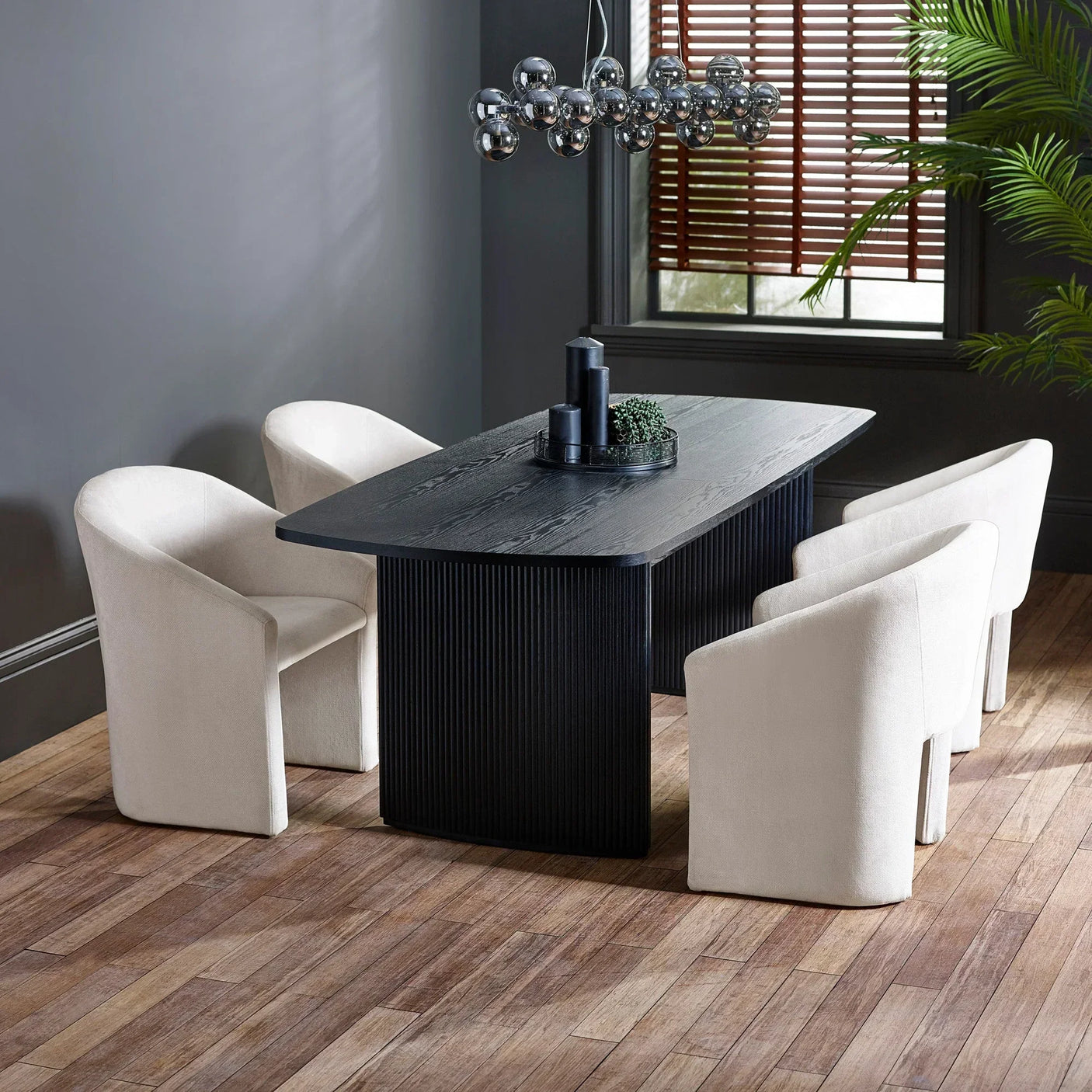 Black wood dining table with cream upholstered chairs in modern dining room setting