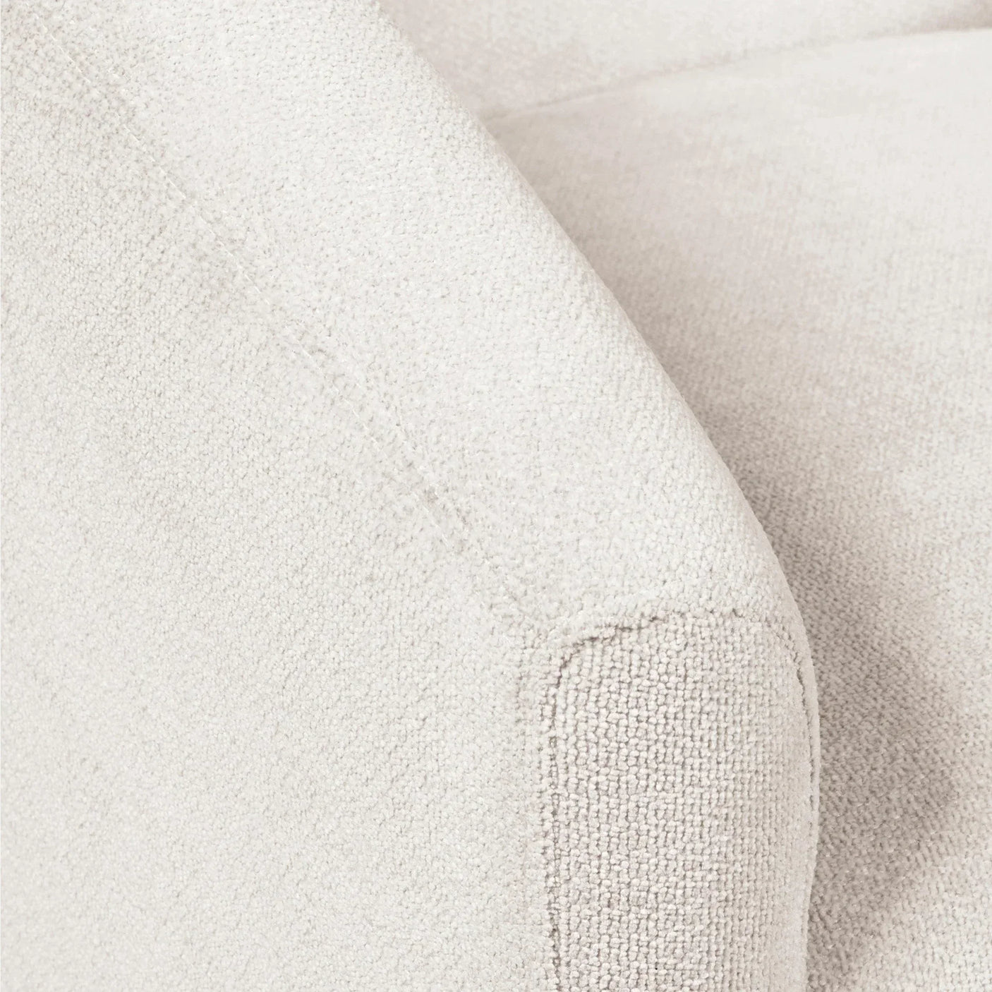 Close-up of cream fabric sofa arm showing textured upholstery and stitching detail