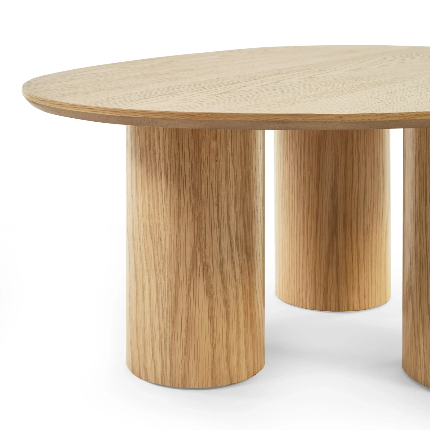 Round oak coffee table with three thick cylindrical legs, close-up angle