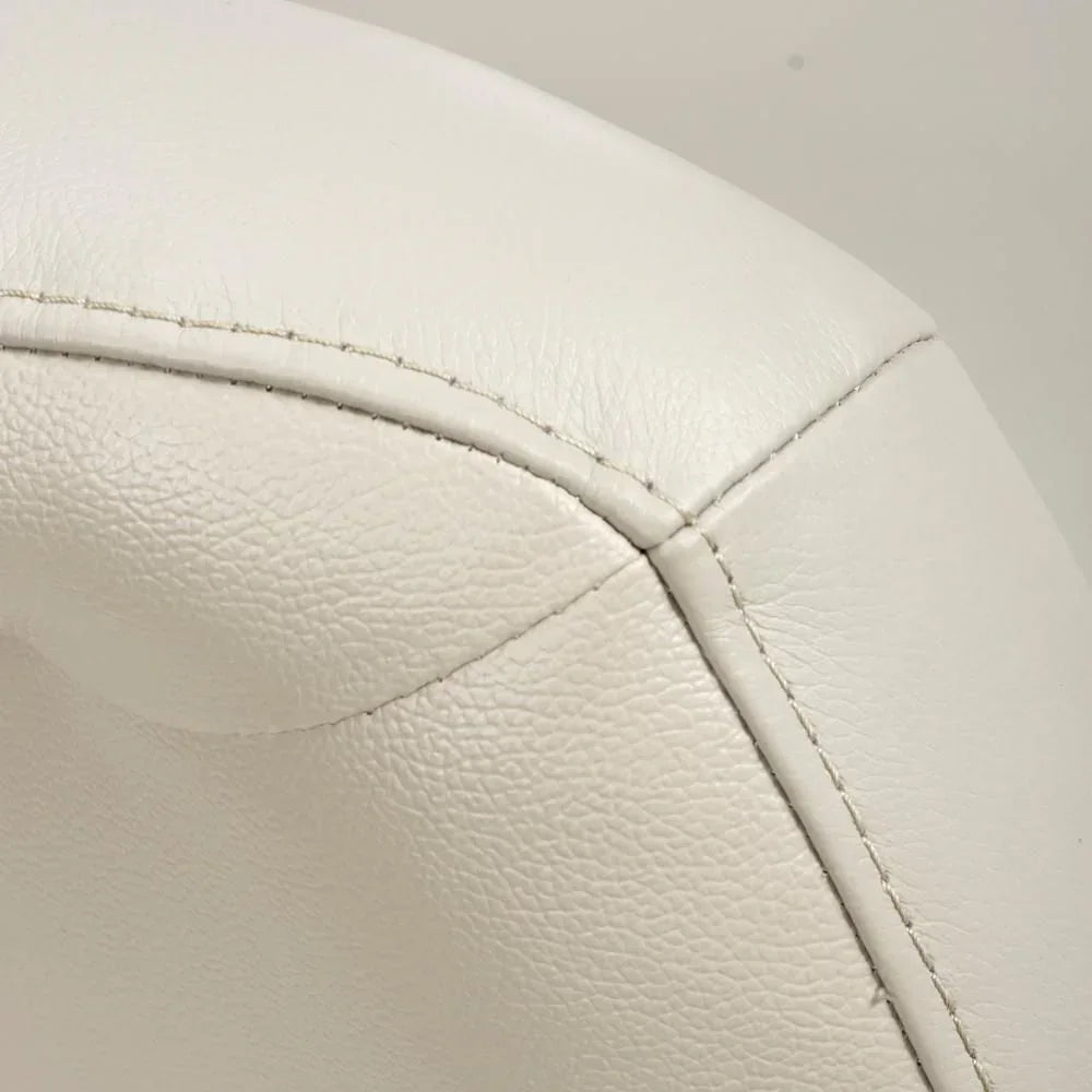 Closeup of cream leather chair backrest with detailed stitching and textured finish