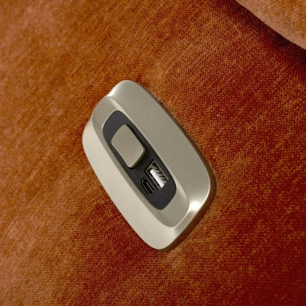Fabric recliner sofa USB charging port on rust orange upholstery closeup