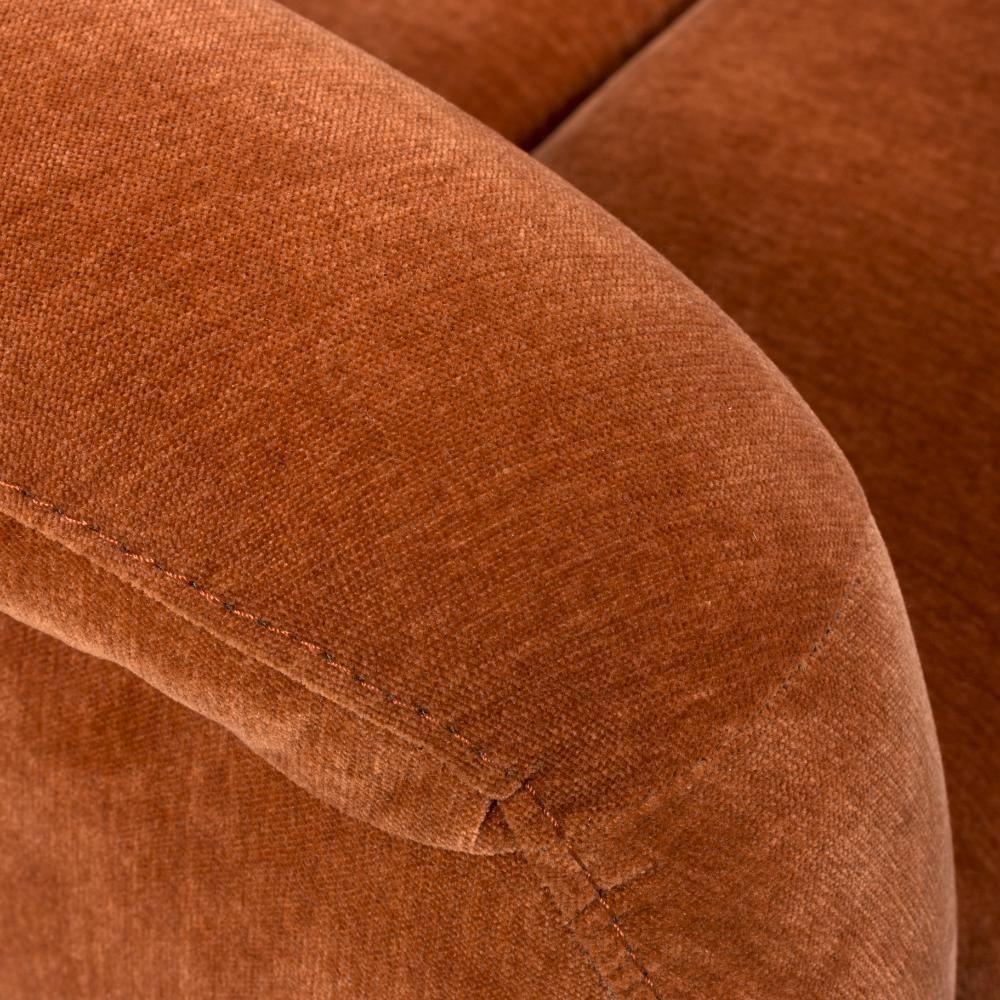 Close-up of rust fabric sofa armrest with visible stitching detail