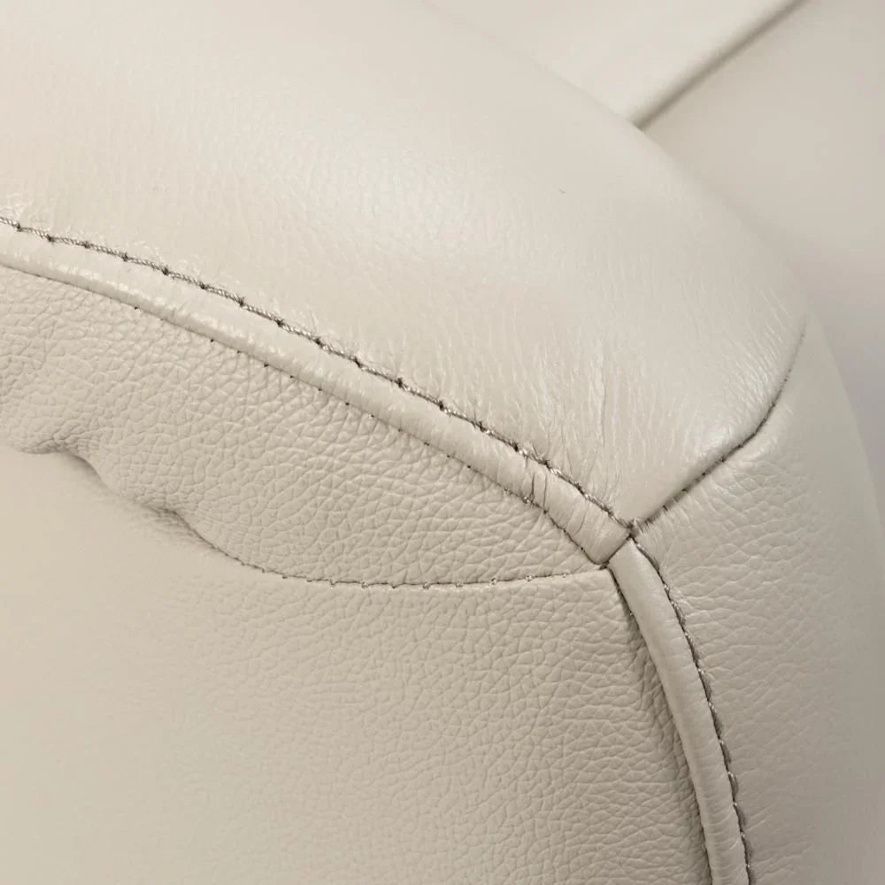 Closeup of beige leather sofa armrest with visible stitching detail
