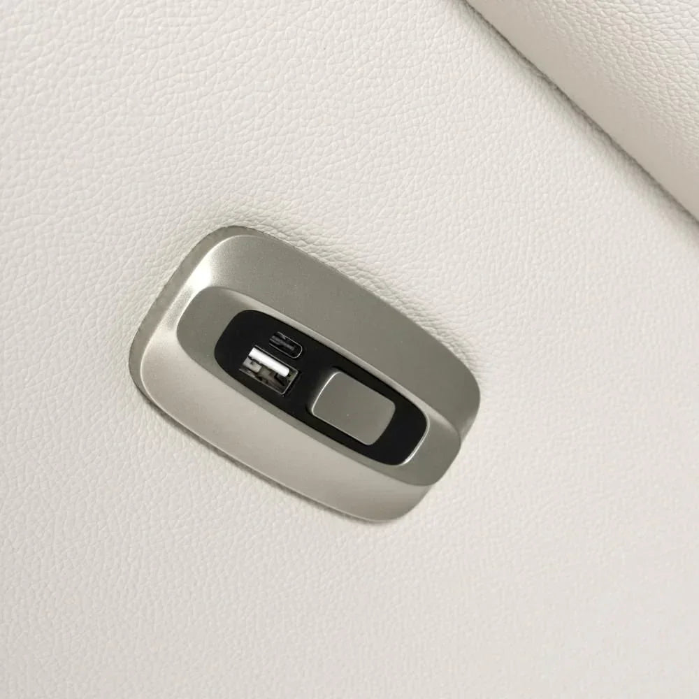 Closeup of white leather sofa USB charging port and control button on armrest