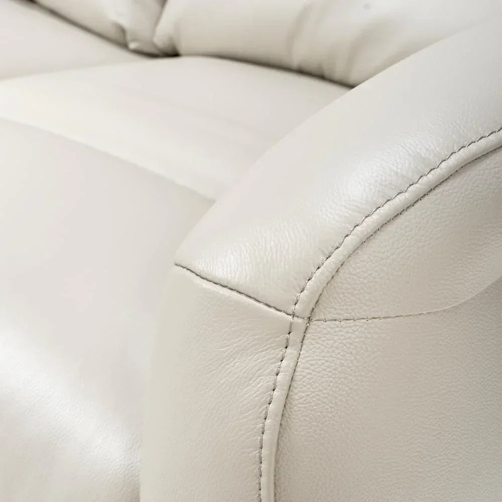 Close-up of cream leather sofa arm with visible stitching and padded seat detail