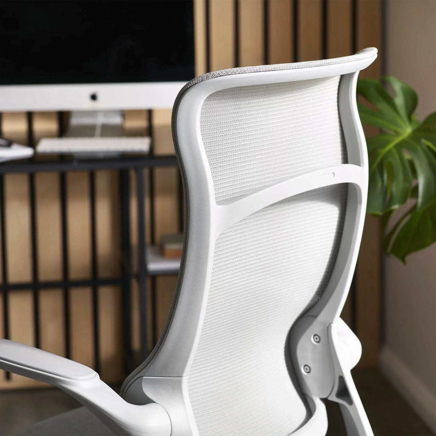 White mesh office chair backrest detail in modern workspace setting