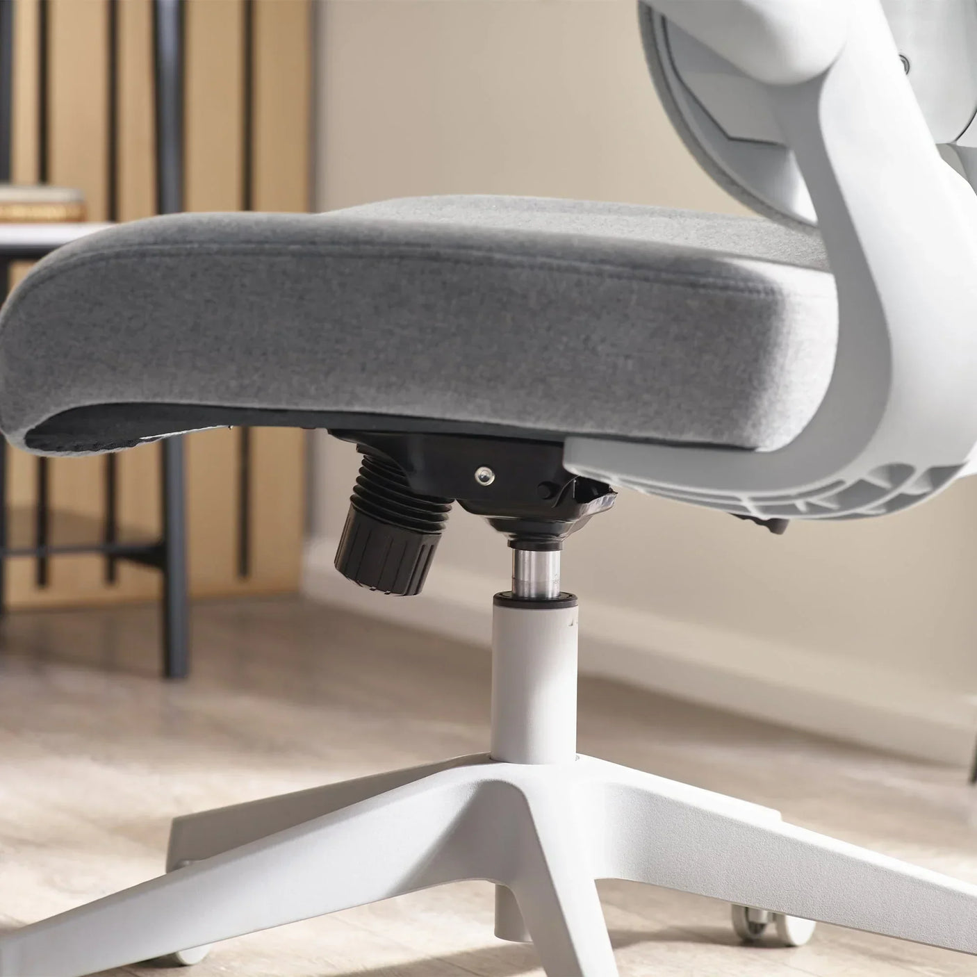 Grey fabric office chair seat with adjustable height base and white frame detail
