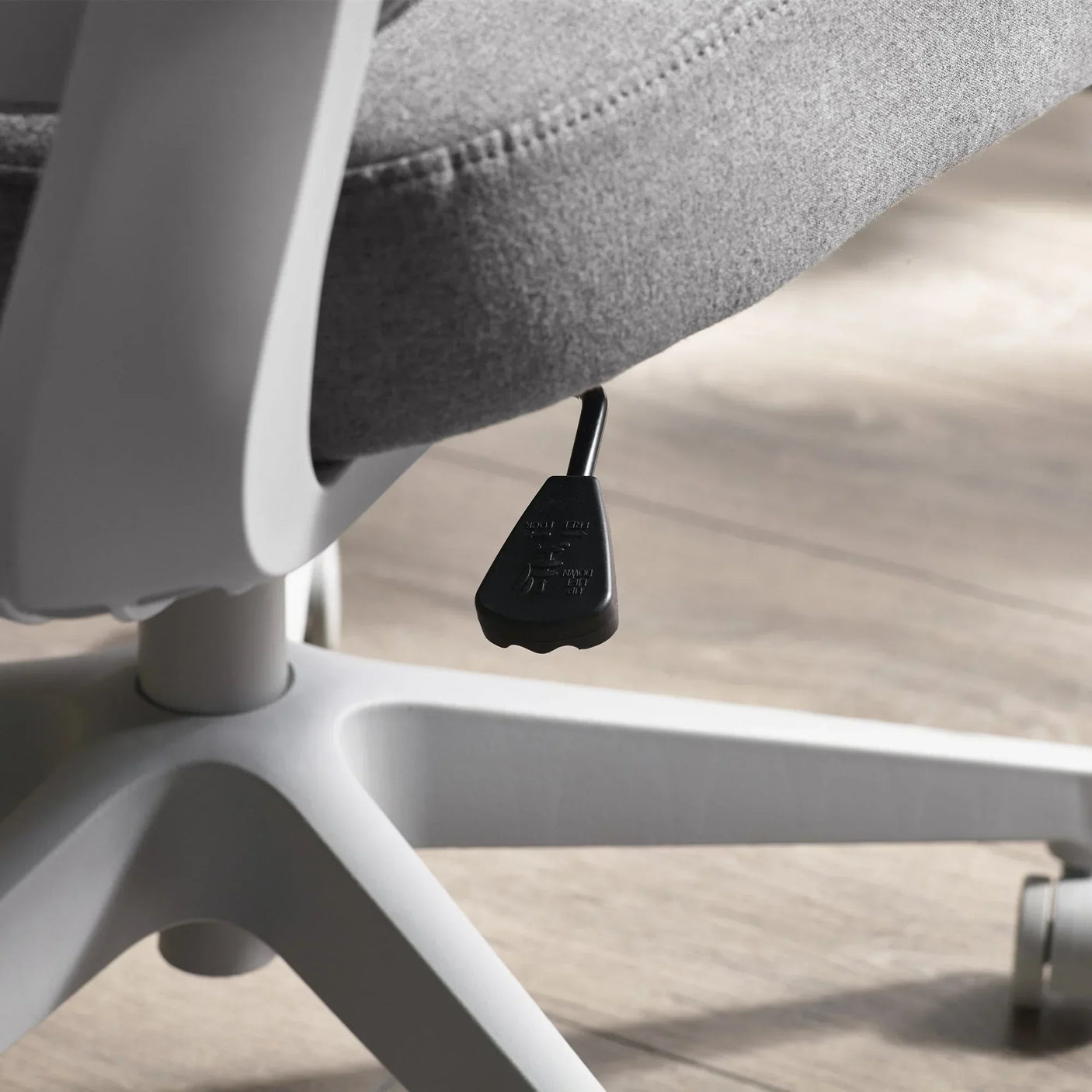 Archer office chair seat adjustment lever and grey fabric detail on wood floor