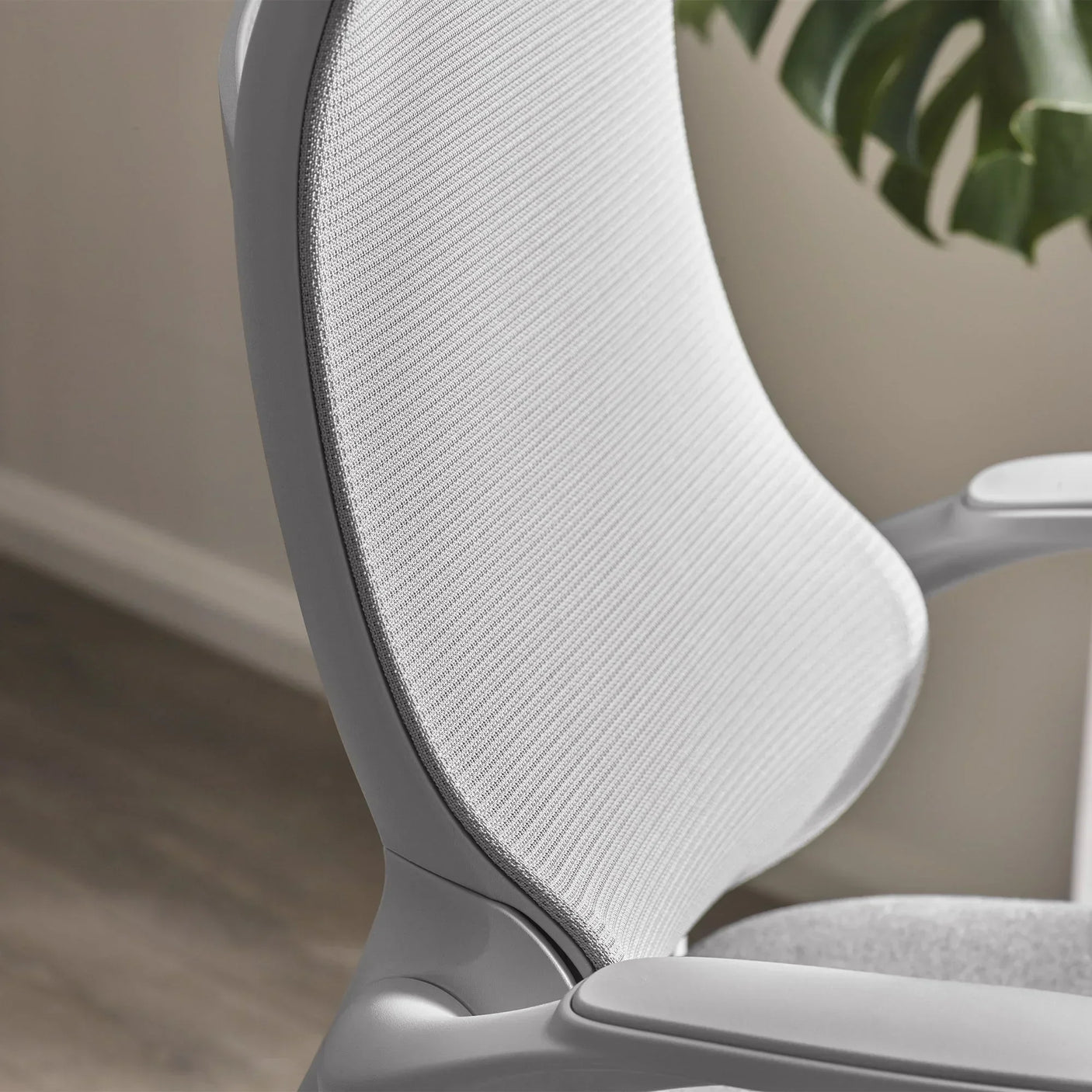 Curved mesh backrest and arm of grey office chair with ergonomic design