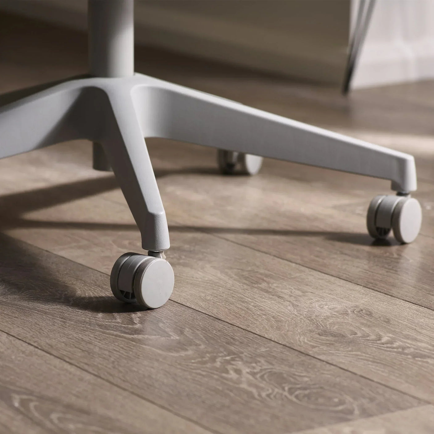Archer office chair base with caster wheels on light wood floor close up