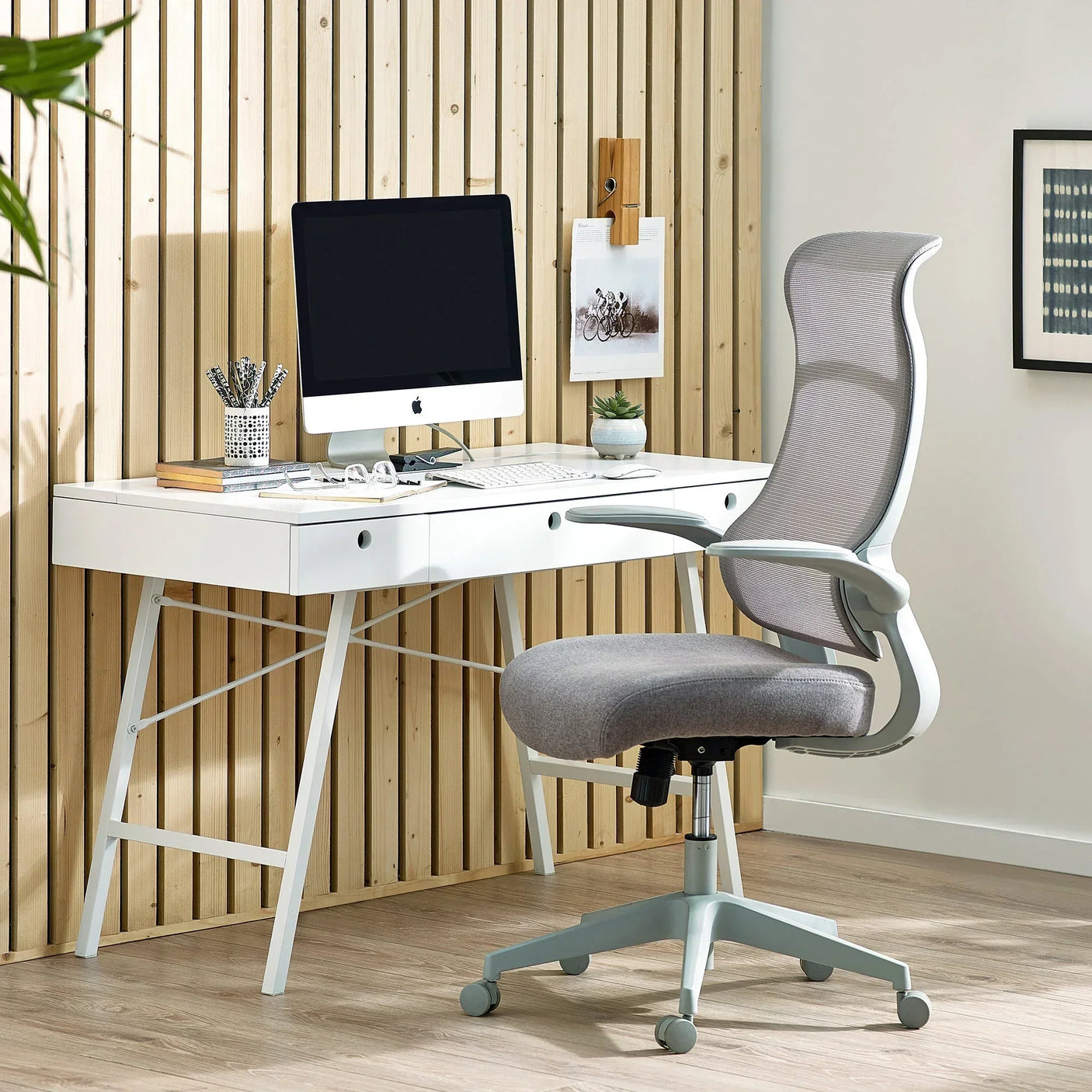 Grey archer office chair with mesh backrest at a white desk in modern home office
