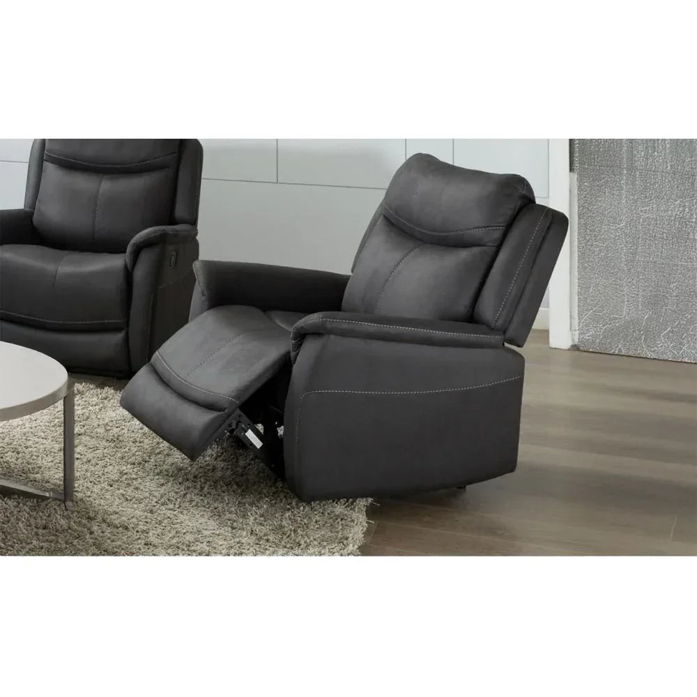 Dark grey recliner armchair with footrest extended on wooden floor next to round table