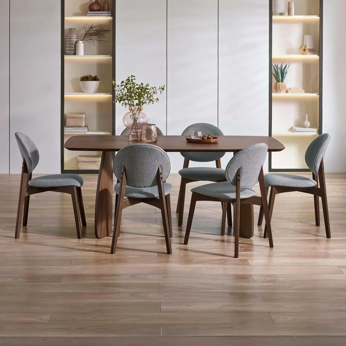 Modern wooden dining table with six grey upholstered chairs in contemporary room setting