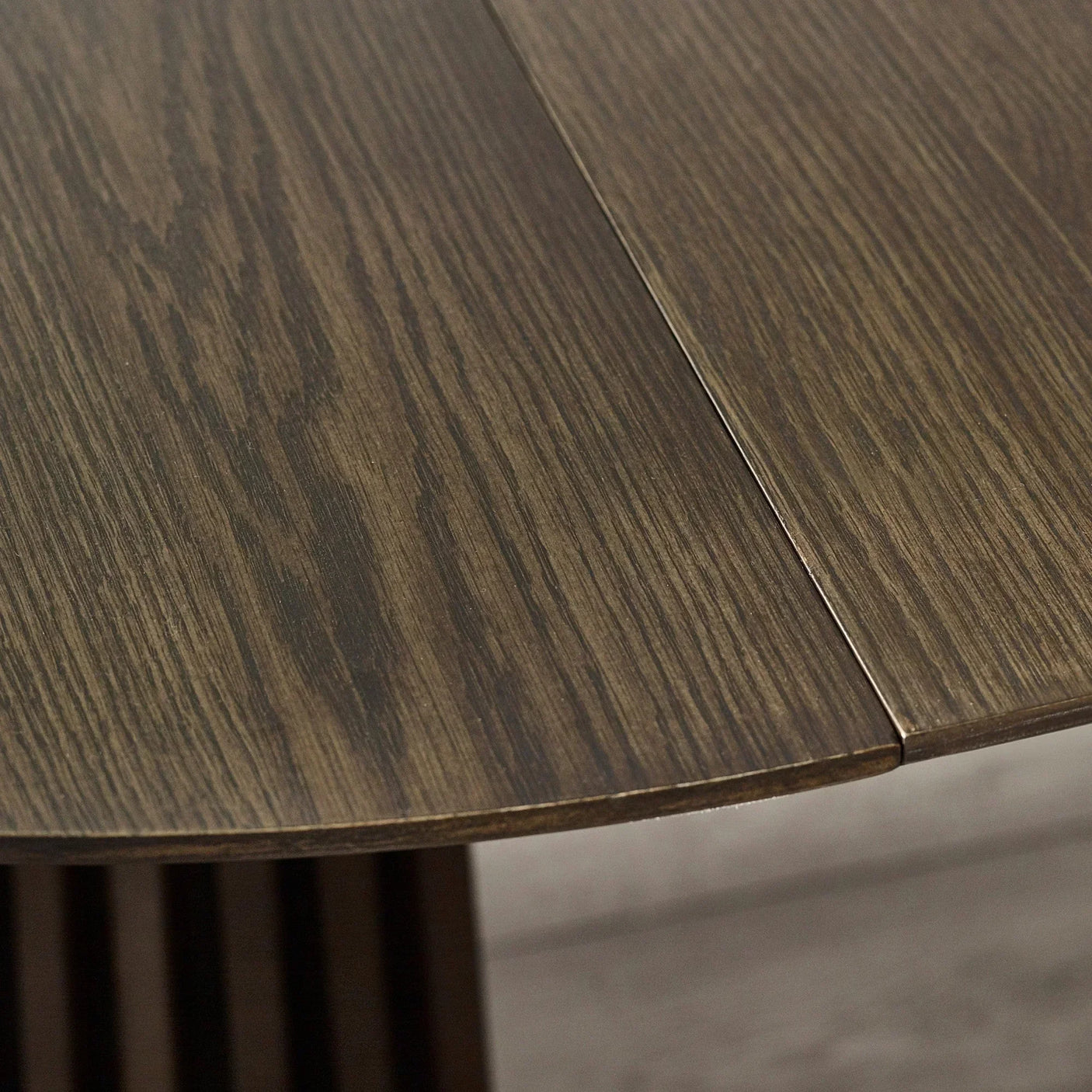 Close-up of dark wood dining table top with visible grain and rounded edge