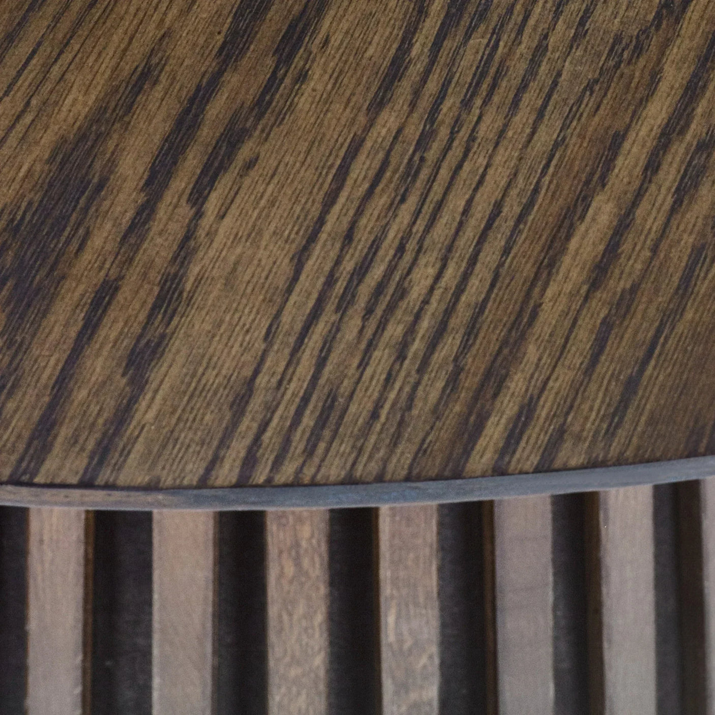Closeup of round wood coffee table top with vertical slatted base detail