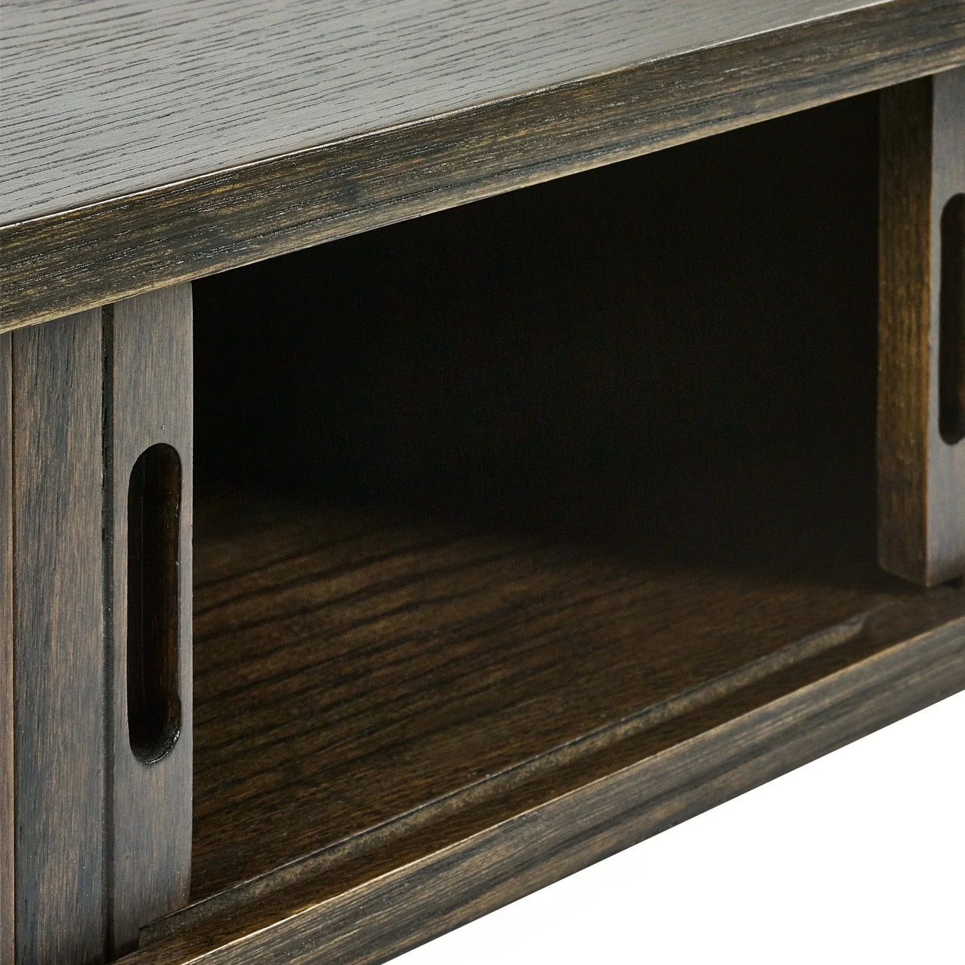 Dark wood TV unit shelf close-up showing sliding door and grooved handle detail