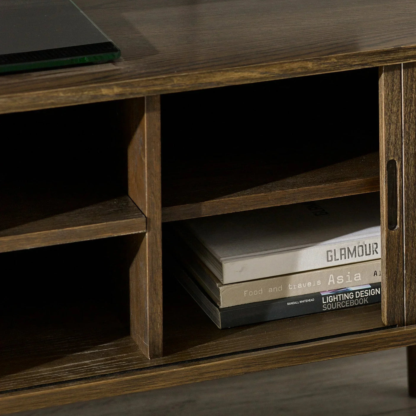 Wooden TV unit shelf with storage books and sliding door detail