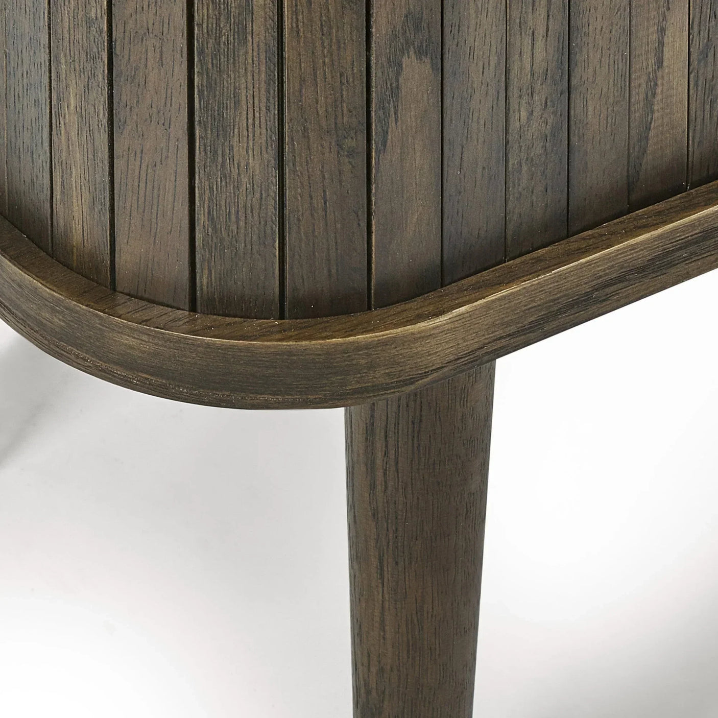 Closeup of dark wood side table leg and slatted detail against a white background