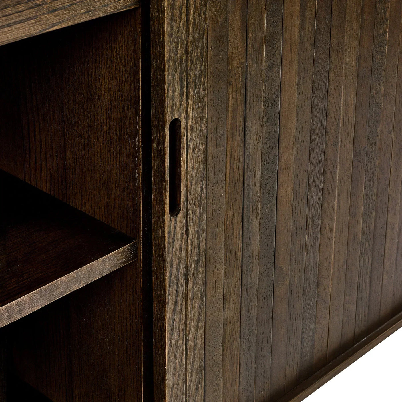 Closeup of dark wood sideboard sliding door with vertical panel detail and shelf interior
