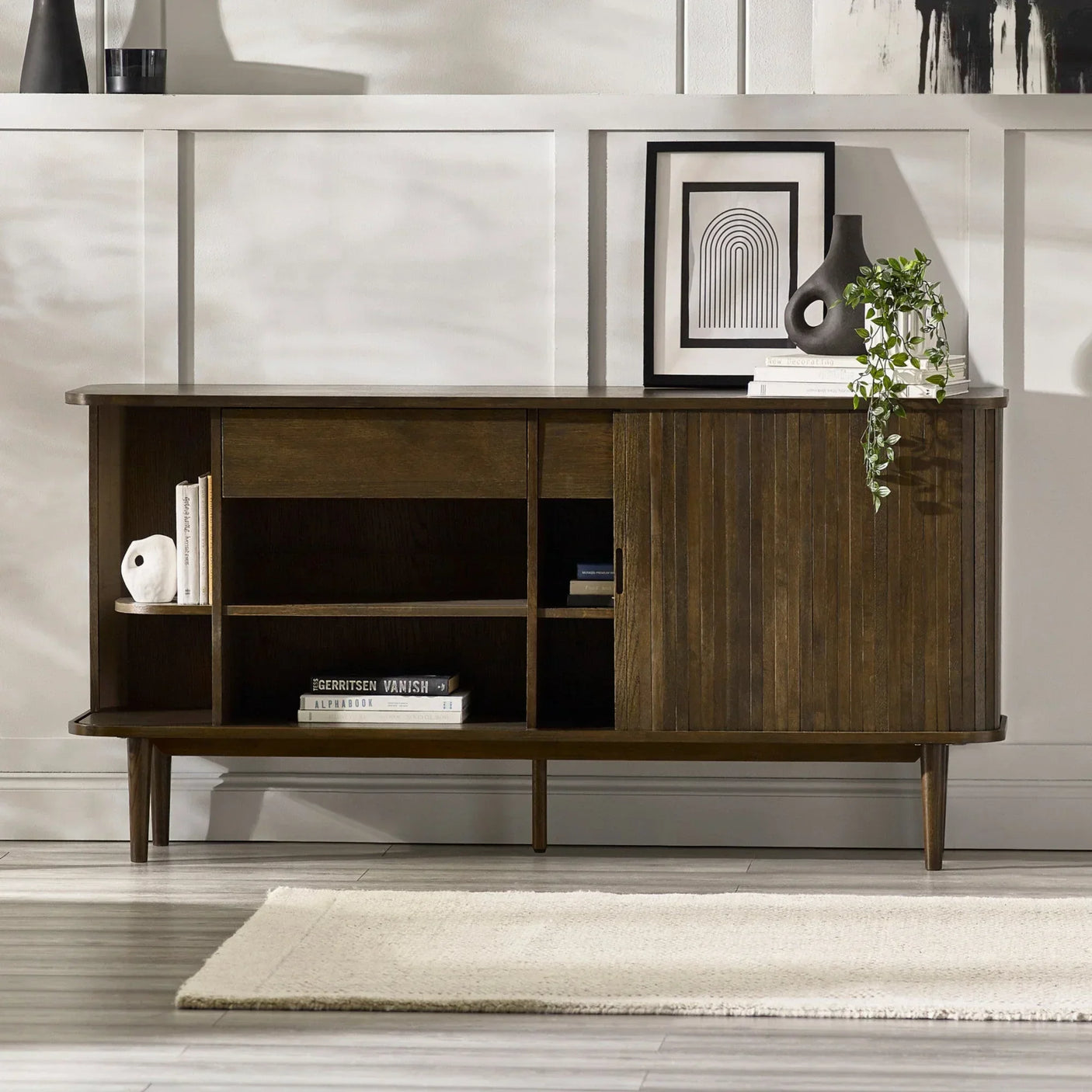 Dark wood sideboard with open shelves, sliding door and books in modern living room