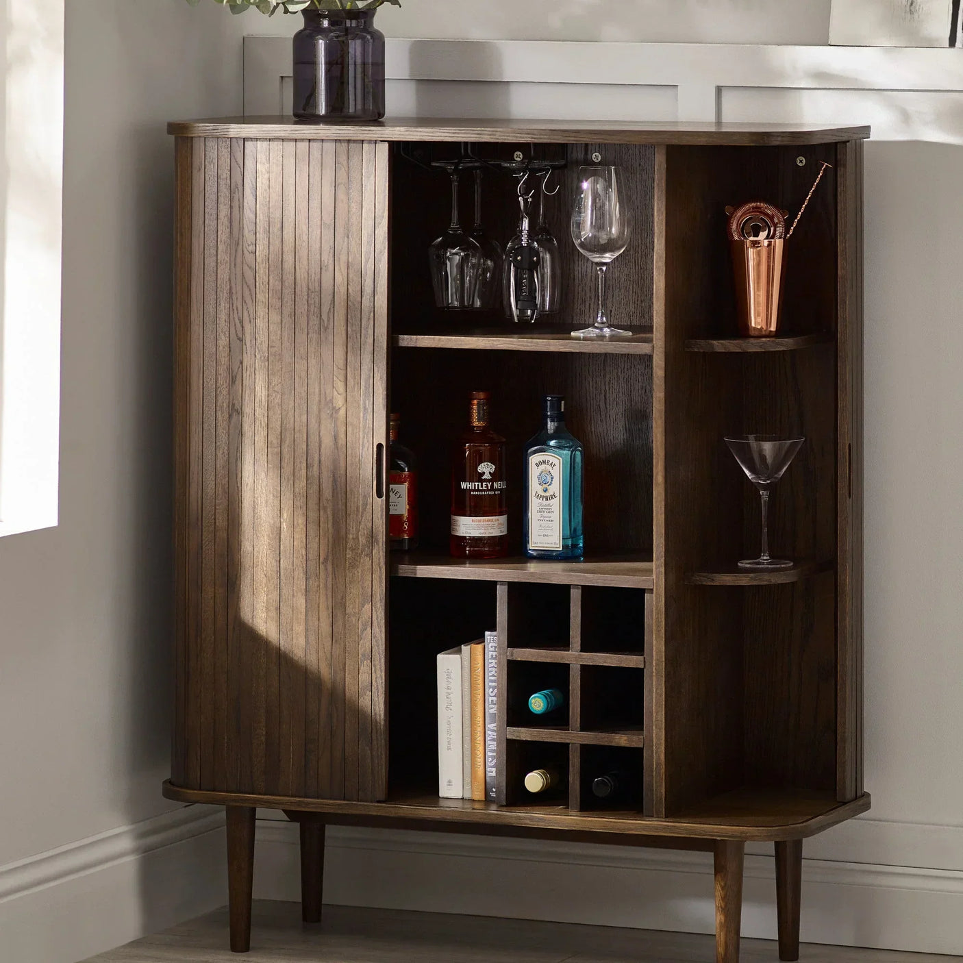Dark wood drinks cabinet with bottle storage shelves, glass rack, and wine rack