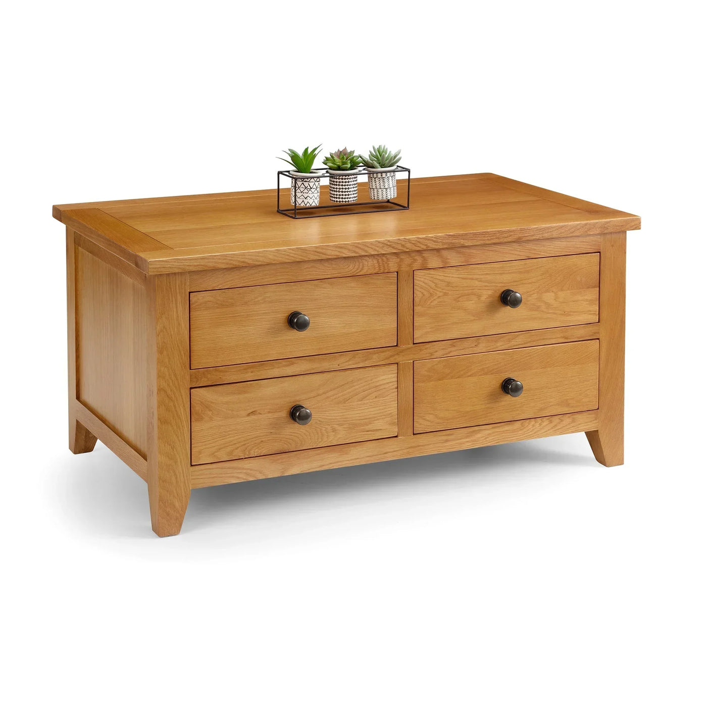 Oak coffee table with four drawers and black knobs, small plants on tabletop