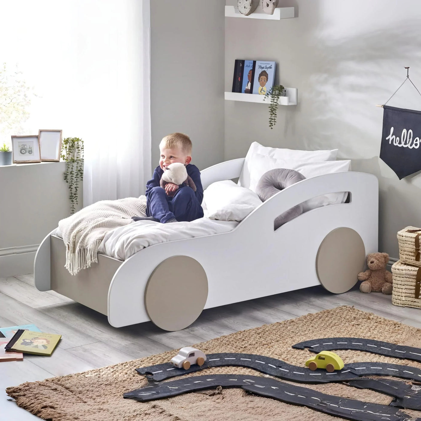 White car-shaped kids bed with beige wheels in a modern children's bedroom