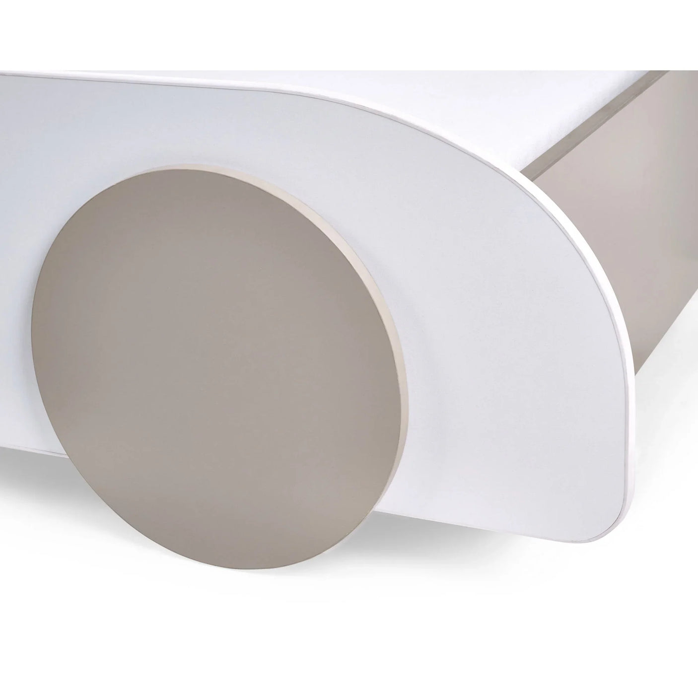 Close-up of modern bed frame with round beige accent and white curved edge panel