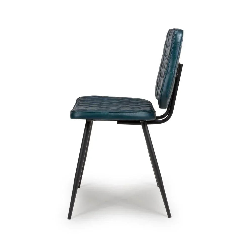 Blue dining chair with black metal legs and quilted upholstery side view