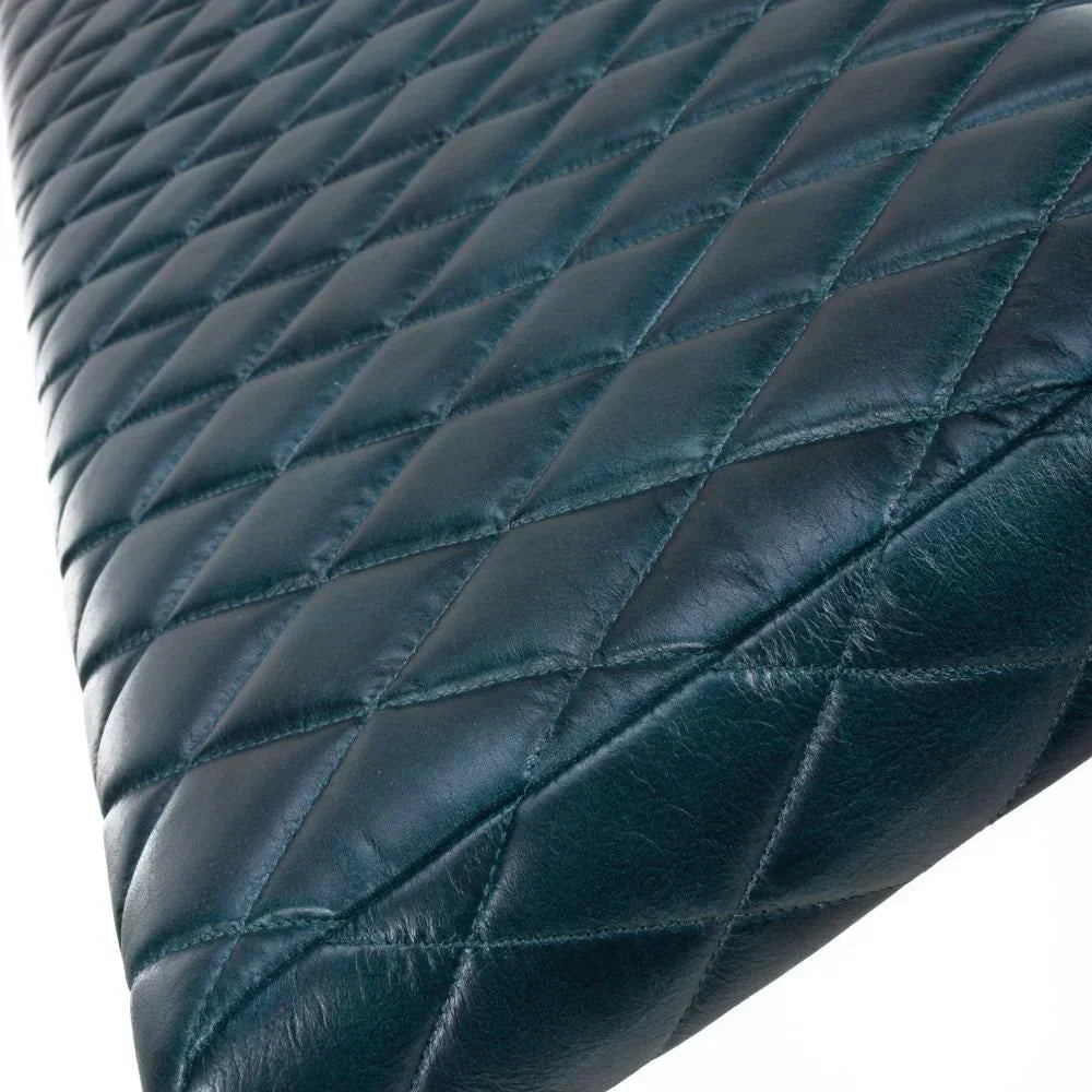 Closeup of black diamond-stitched leather upholstery on a furniture seat