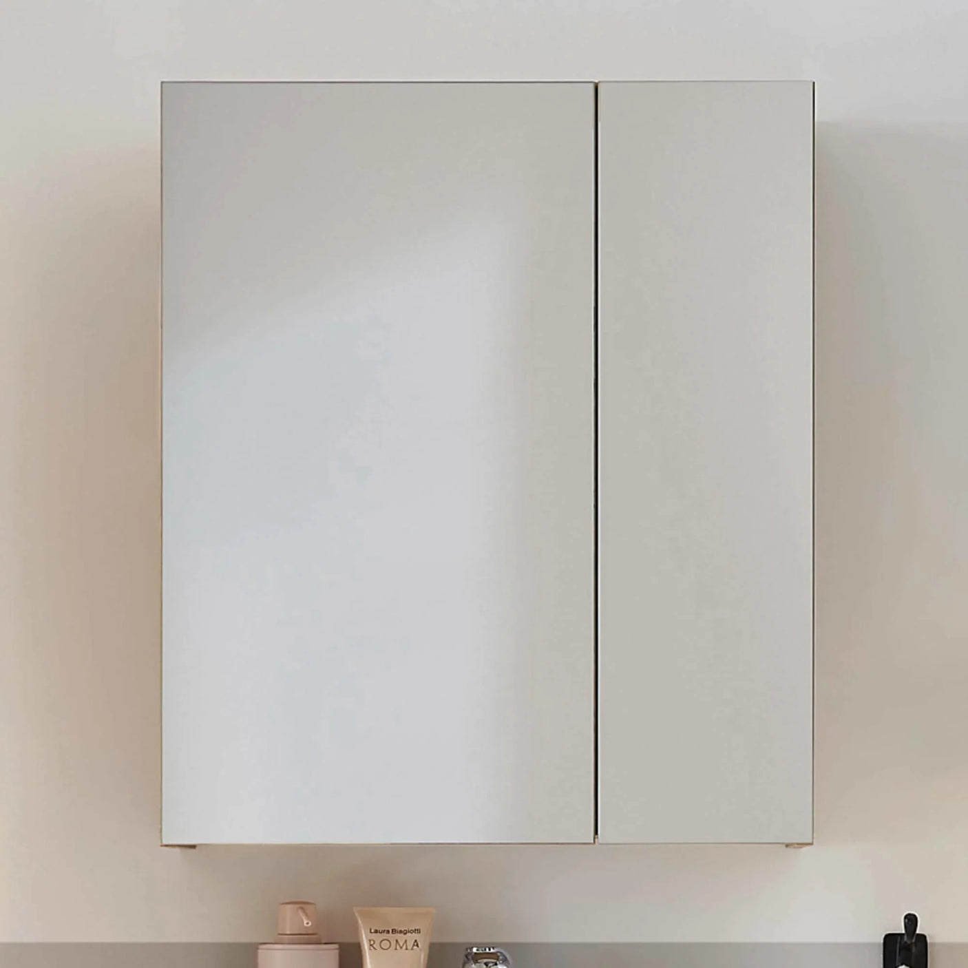 White wall-mounted bathroom cabinet with two doors above a countertop