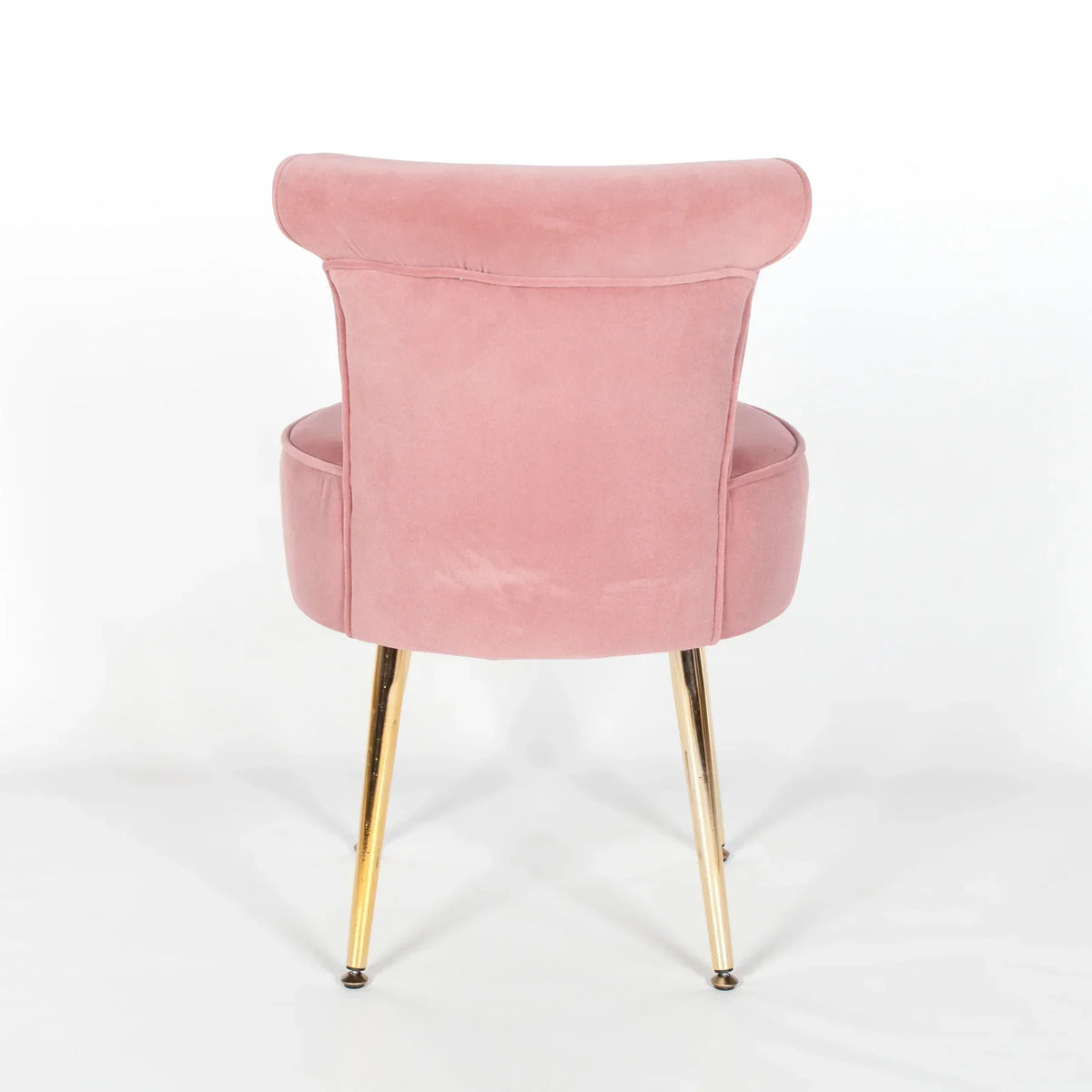 Pink velvet dining chair with gold legs shown from the back