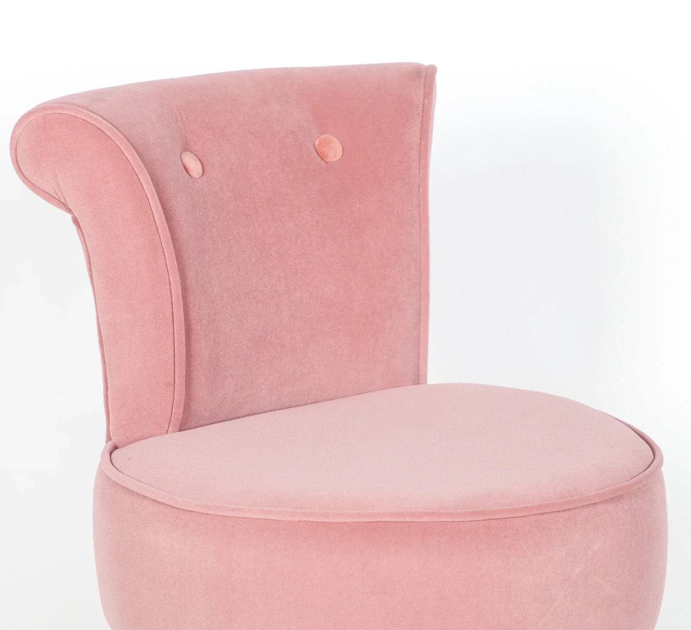 Pink velvet accent chair with curved backrest and button details, side angle view