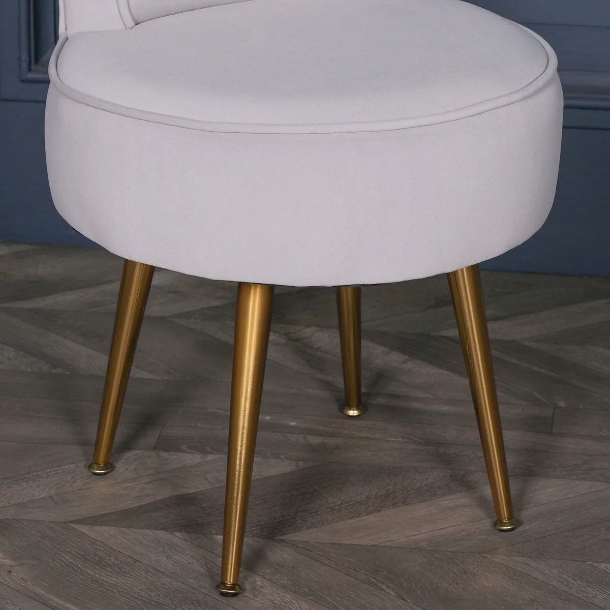 Velvet accent chair with gold metal legs on herringbone wood floor