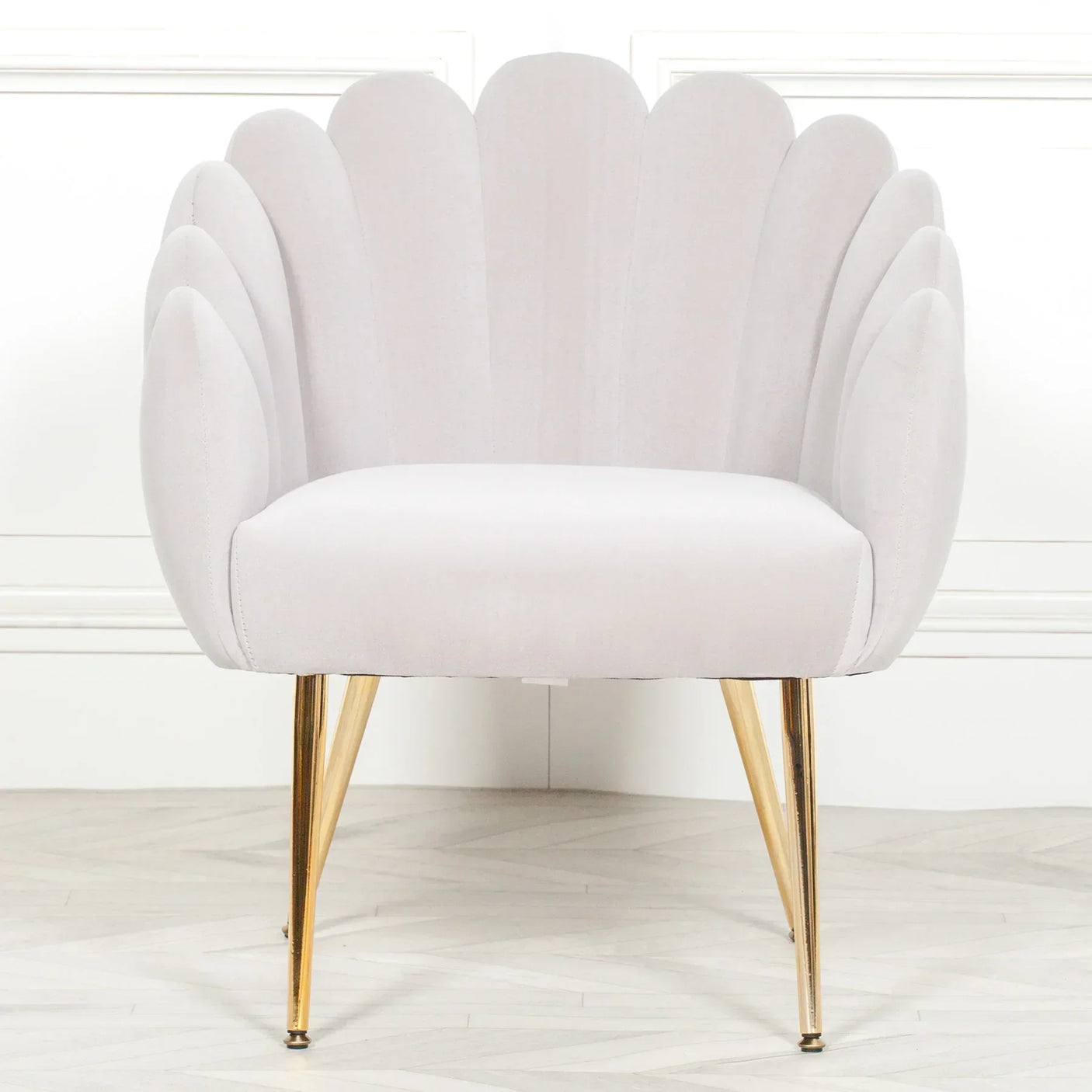 Light grey scallop accent chair with gold legs on wooden floor