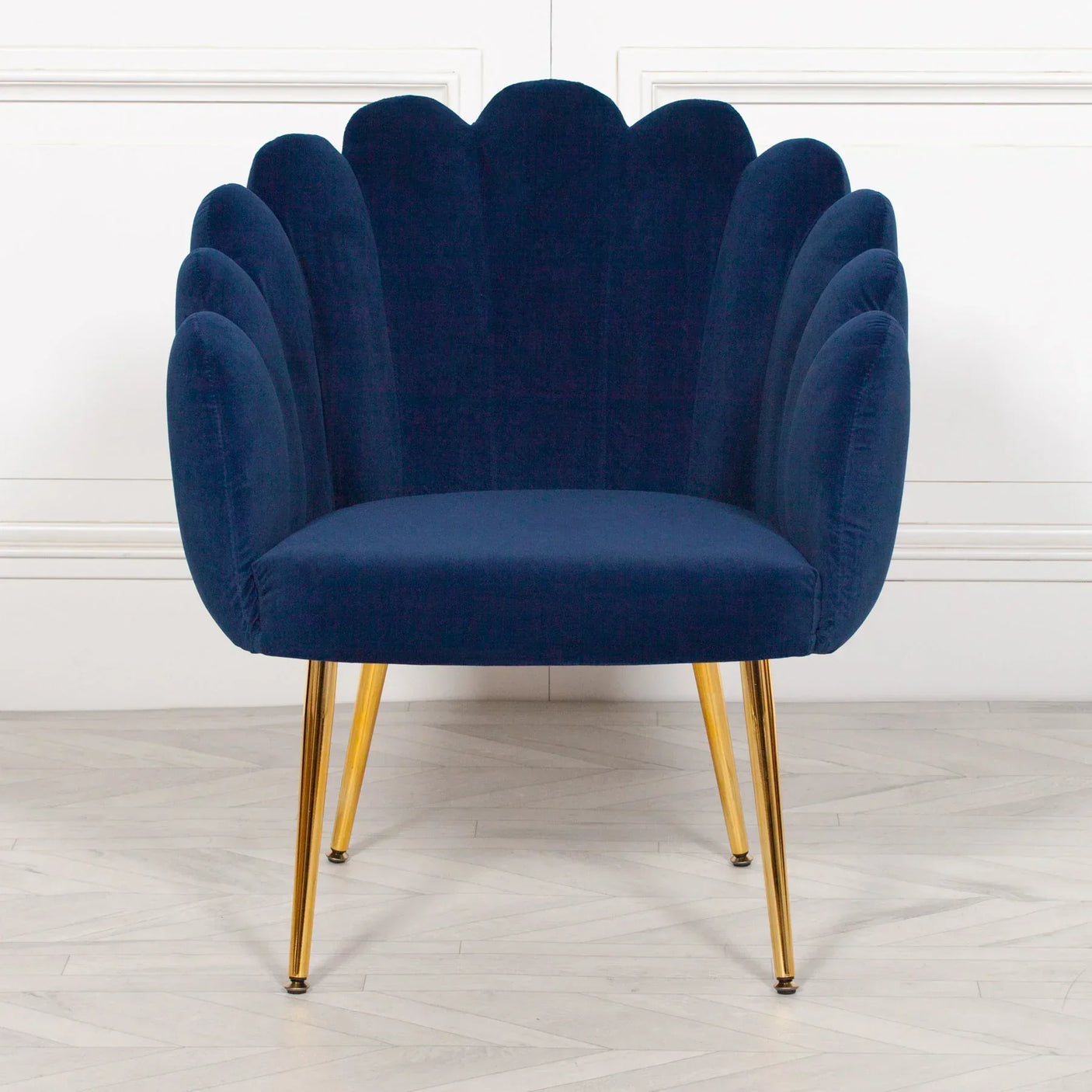 Navy blue velvet accent chair with gold metal legs and scalloped backrest
