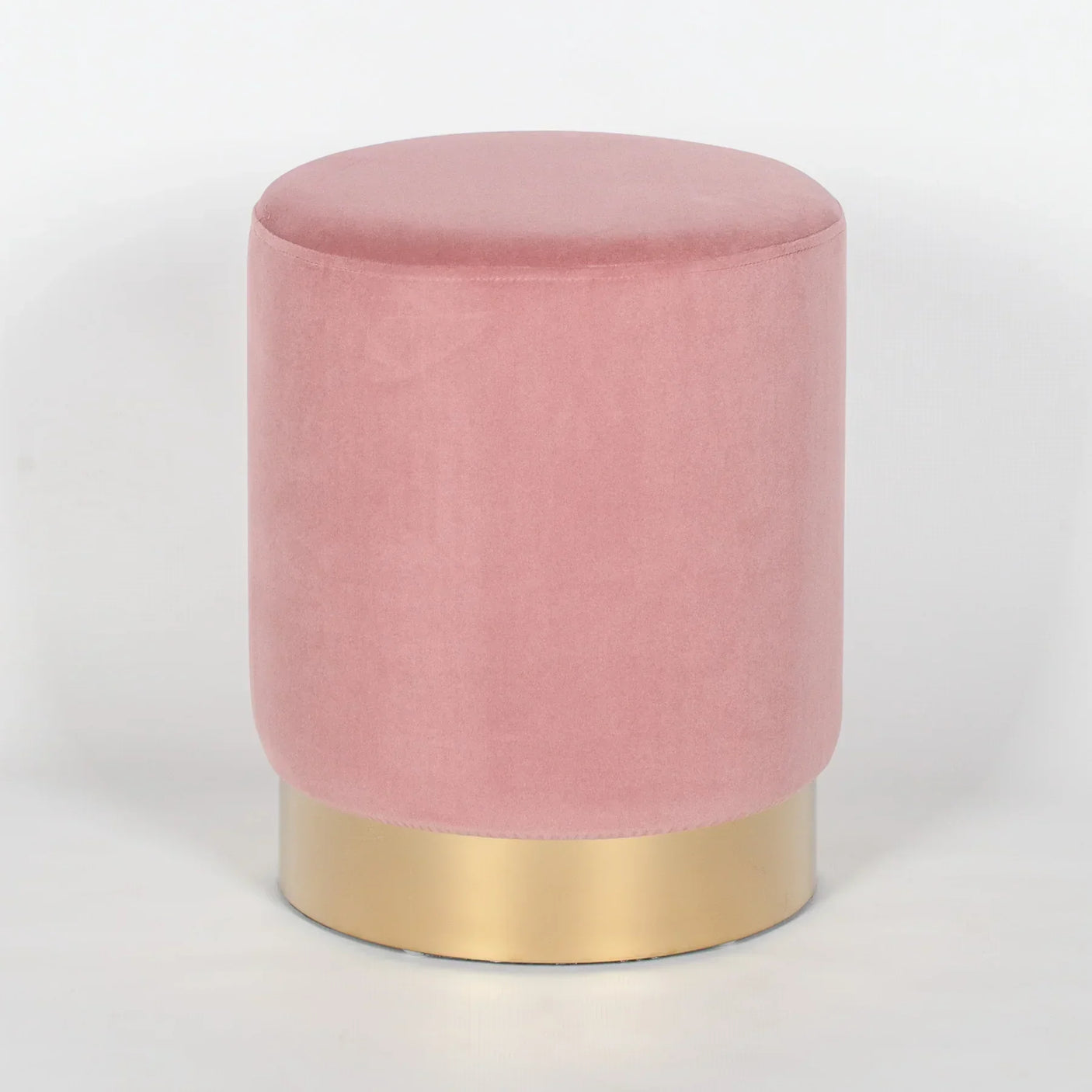Pink velvet footstool with gold metal base on white background